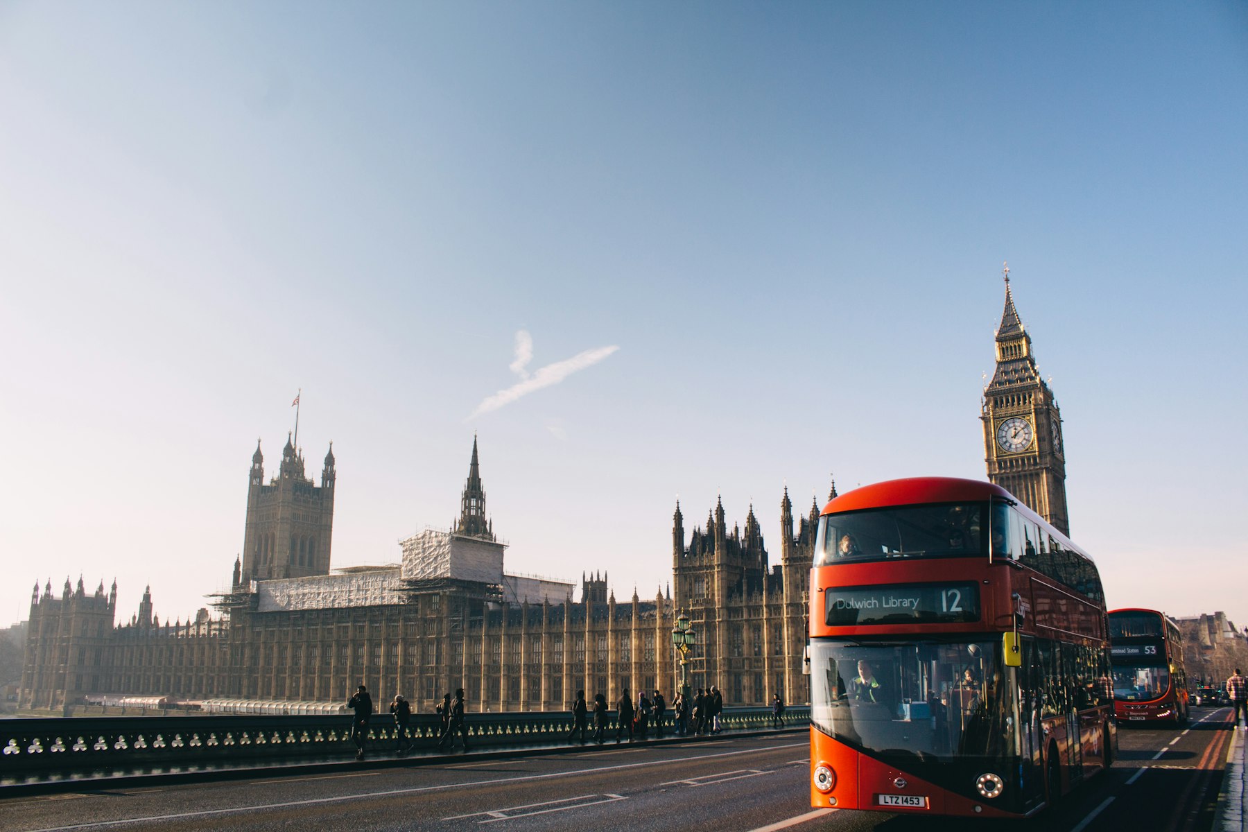 A red double-decker bus passing the Palace of Westminster